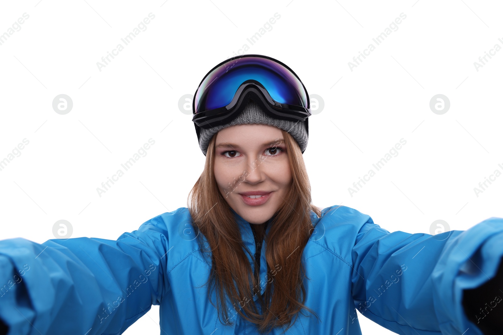 Photo of Beautiful woman in ski goggles taking selfie on white background