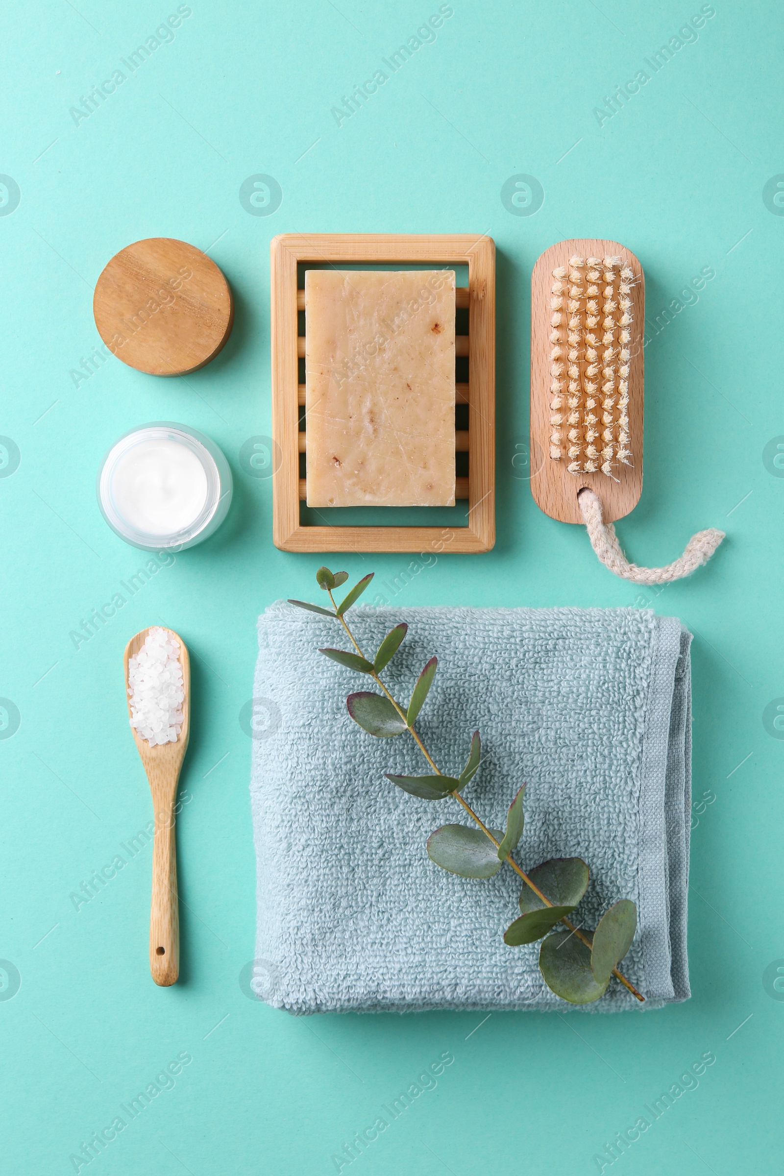 Photo of Jar of cream, body care products and eucalyptus branch on turquoise background, flat lay