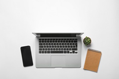 Laptop, smartphone, notebook and houseplant on white background, flat lay. Space for text