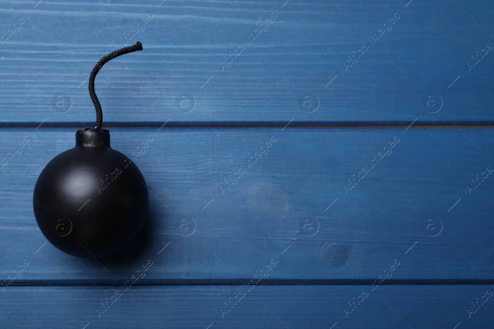 Photo of Old fashioned fuse bomb on blue wooden table, top view. Space for text