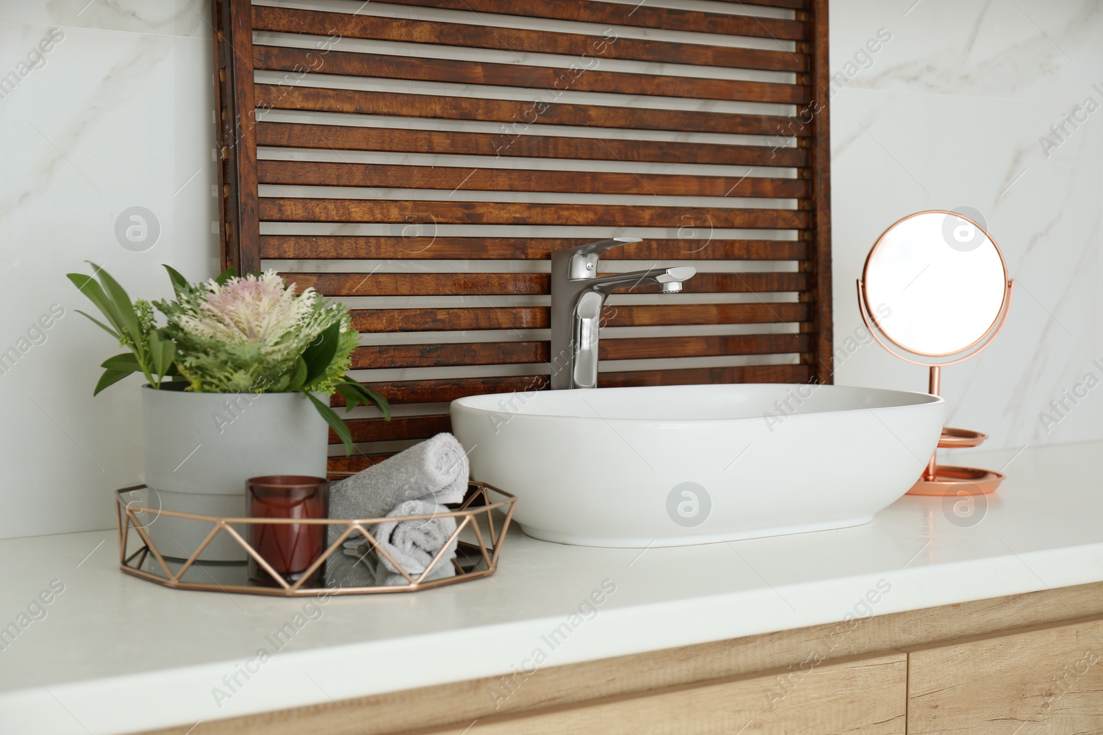 Photo of Bathroom counter with stylish vessel sink and small mirror. Interior design