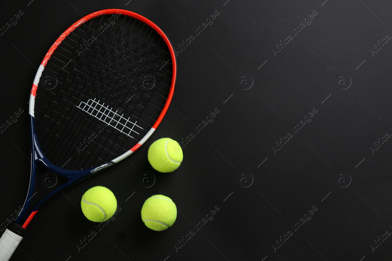Photo of Tennis racket and balls on black background, flat lay. Space for text