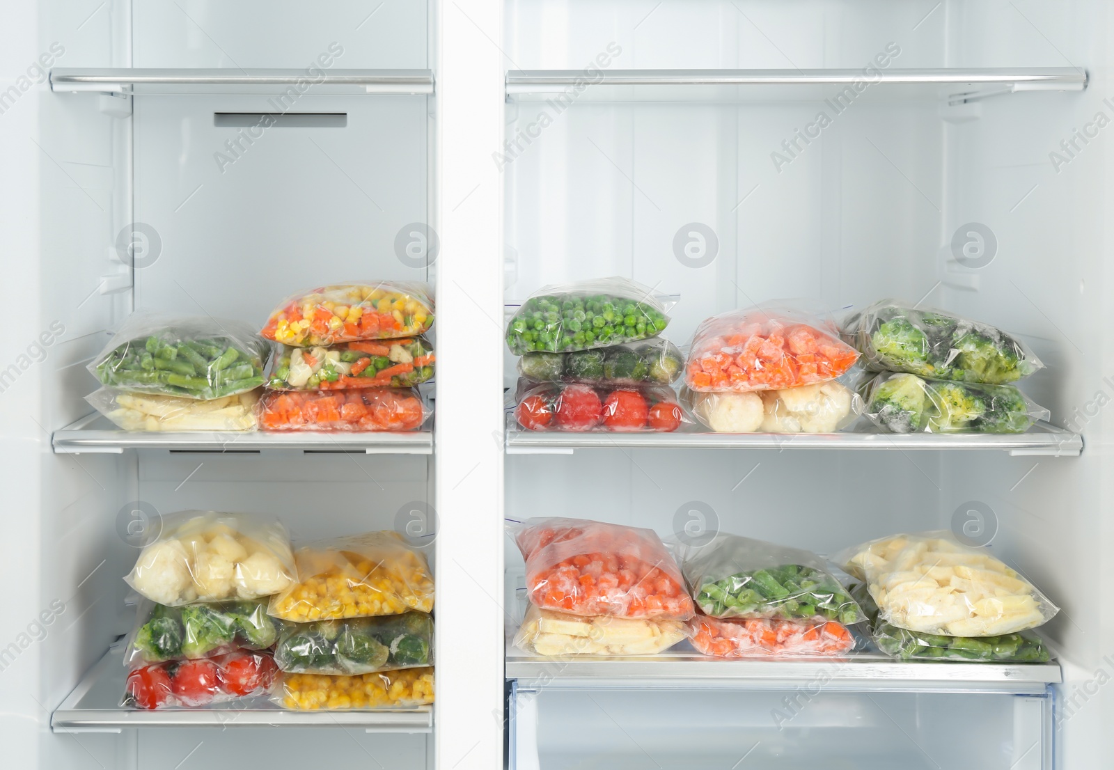 Photo of Plastic bags with different frozen vegetables in refrigerator