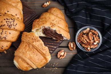 Photo of Flat lay composition with tasty croissants and walnuts on wooden table