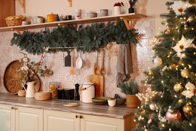 Stylish kitchen with festive decor and Christmas tree. Interior design