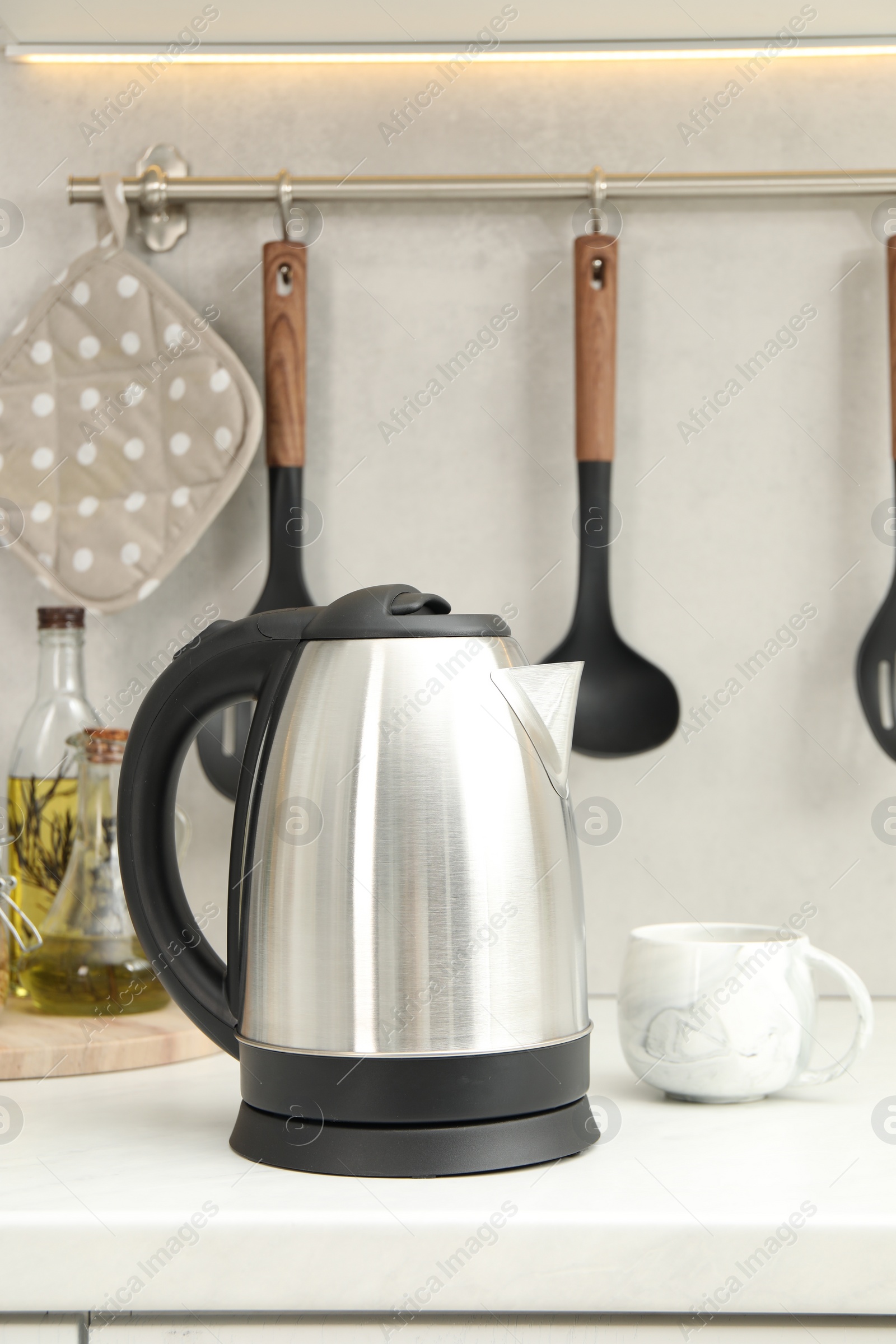 Photo of Electric kettle and cup on counter in kitchen