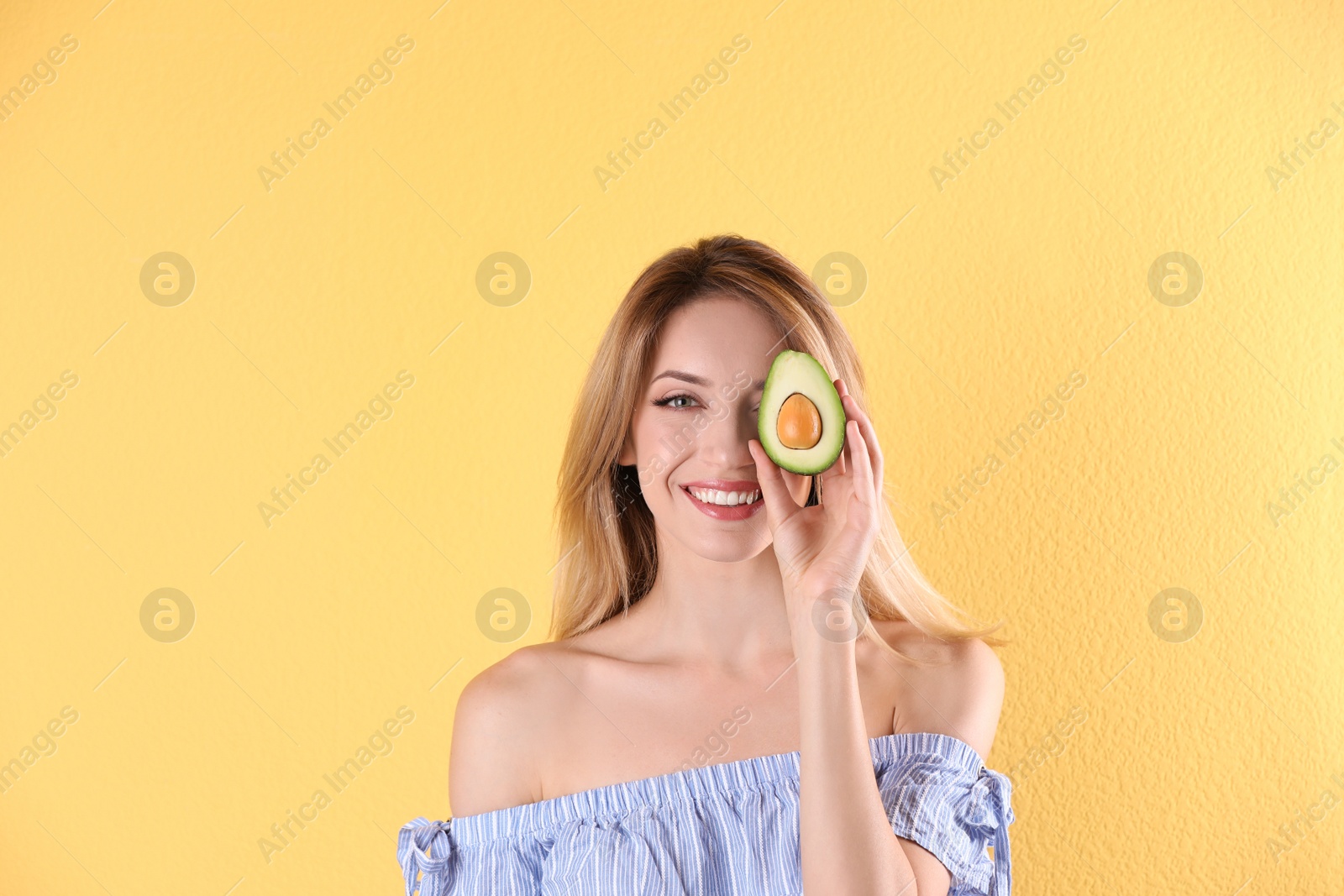 Photo of Portrait of young beautiful woman with ripe delicious avocado on color background