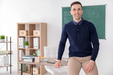 Photo of Young male teacher in classroom