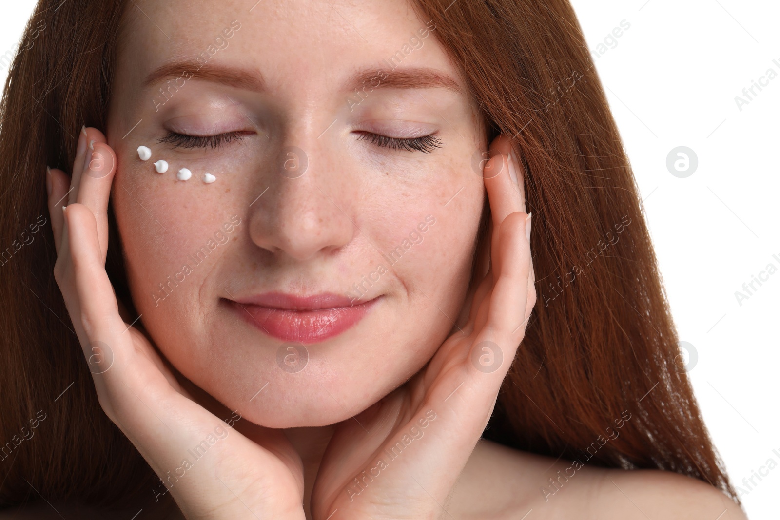 Photo of Beautiful woman with freckles and cream on her face against white background, closeup