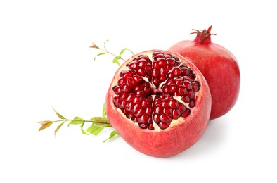 Photo of Fresh ripe pomegranates and green leaves isolated on white