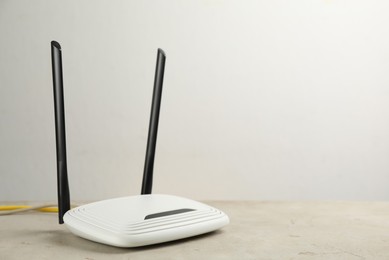 Modern Wi-Fi router on light table. Space for text