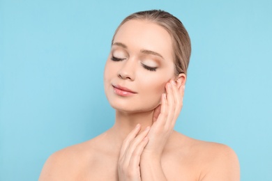 Photo of Portrait of young woman with beautiful face on blue background