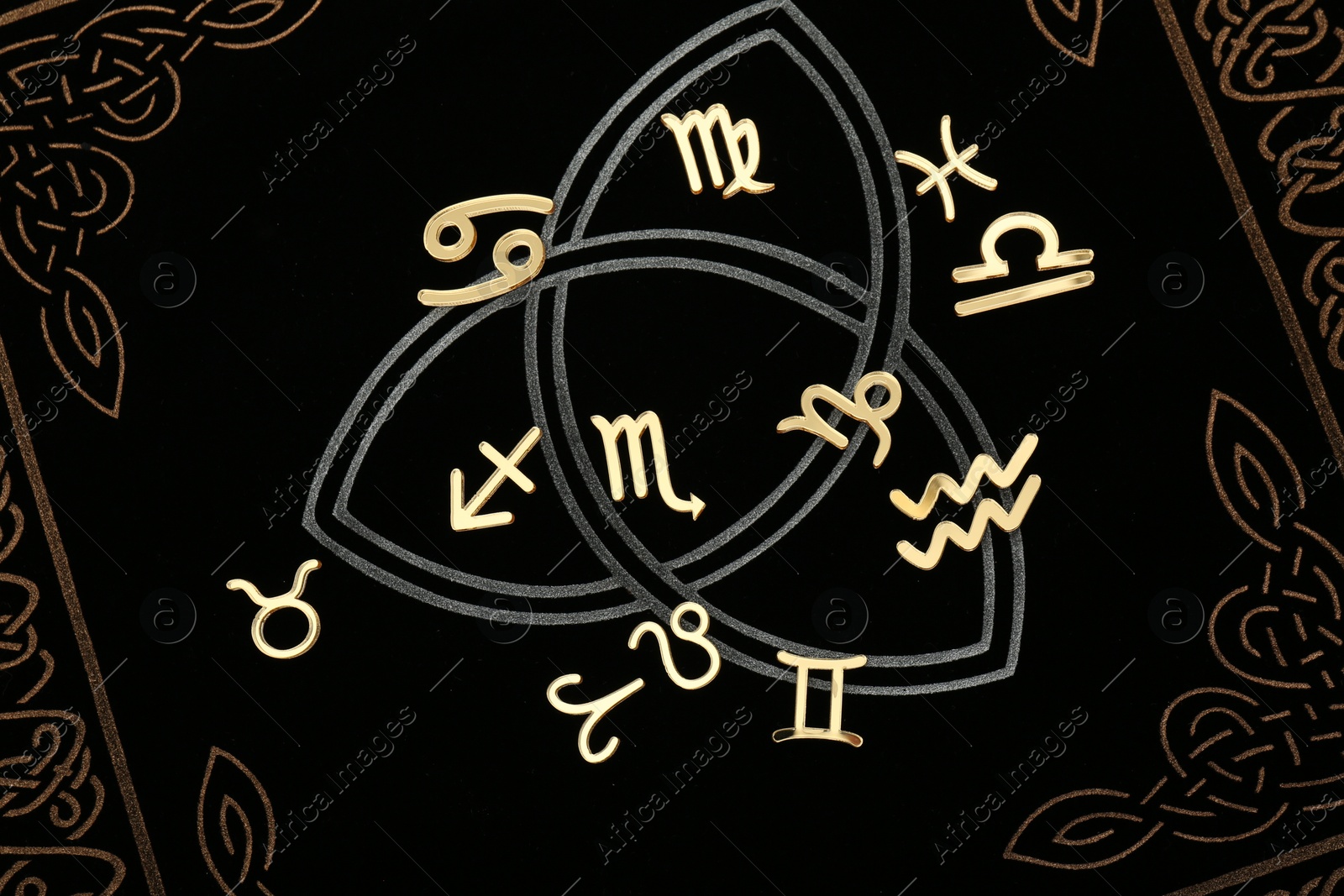 Photo of Zodiac signs on dark book, flat lay