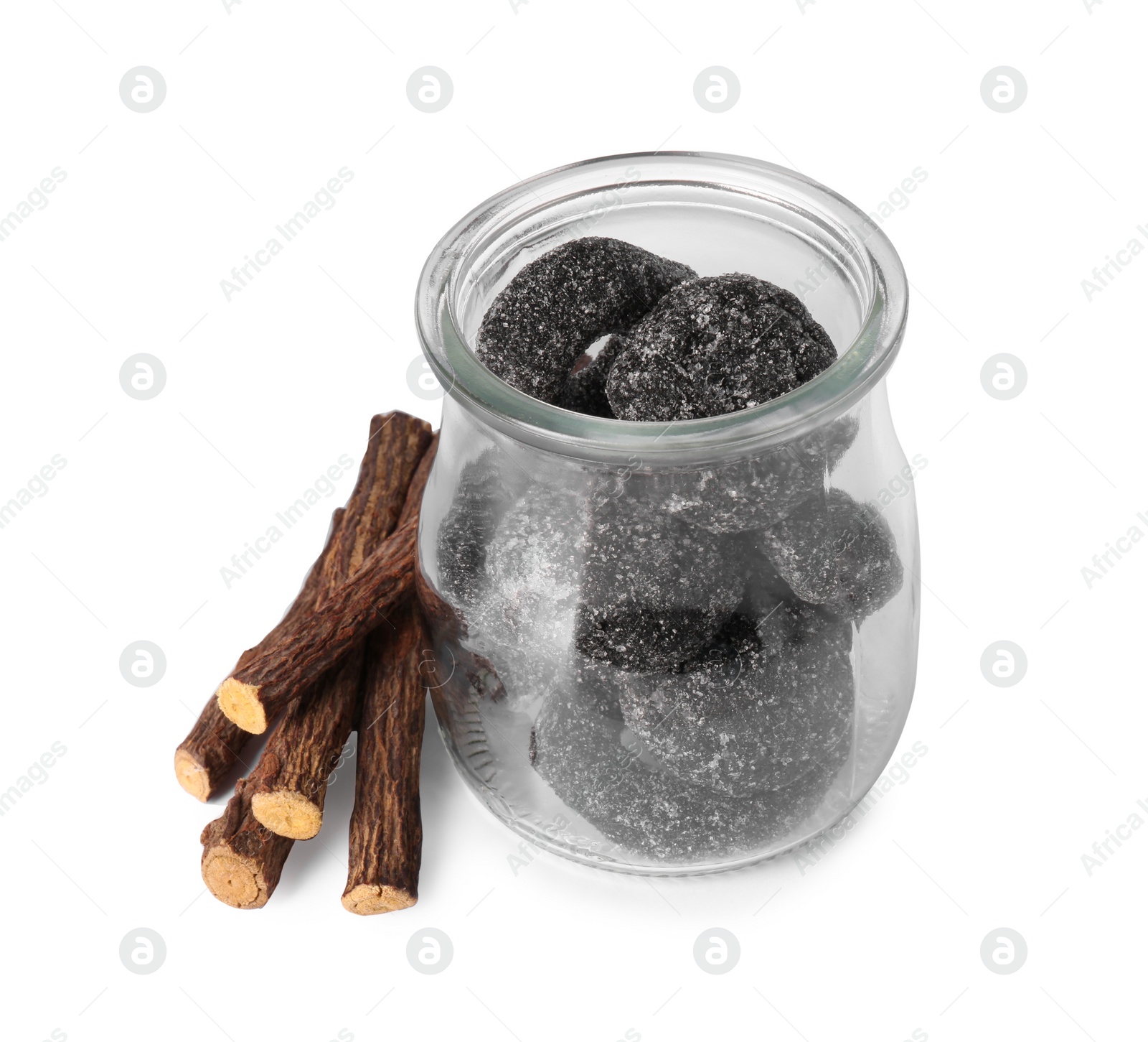 Photo of Glass jar of tasty candies and dried cut liquorice root isolated on white