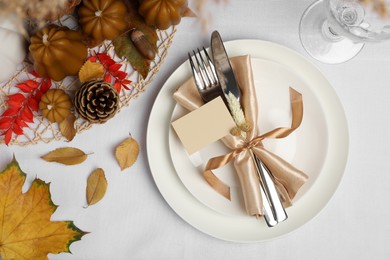 Photo of Beautiful autumn place setting with blank card and decor for festive dinner on table, flat lay