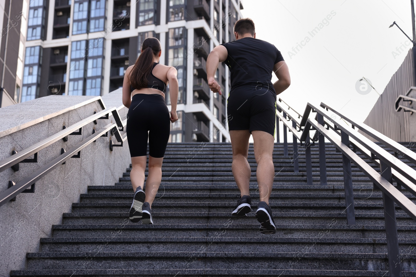 Photo of Healthy lifestyle. Couple running up steps outdoors, low angle view