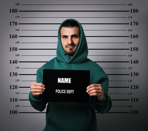 Image of Criminal mugshot. Arrested man with blank card against height chart