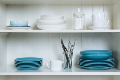 Photo of White shelving unit with set of dishware