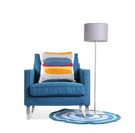 Photo of Comfortable armchair with pillow and lamp on white background. Interior element