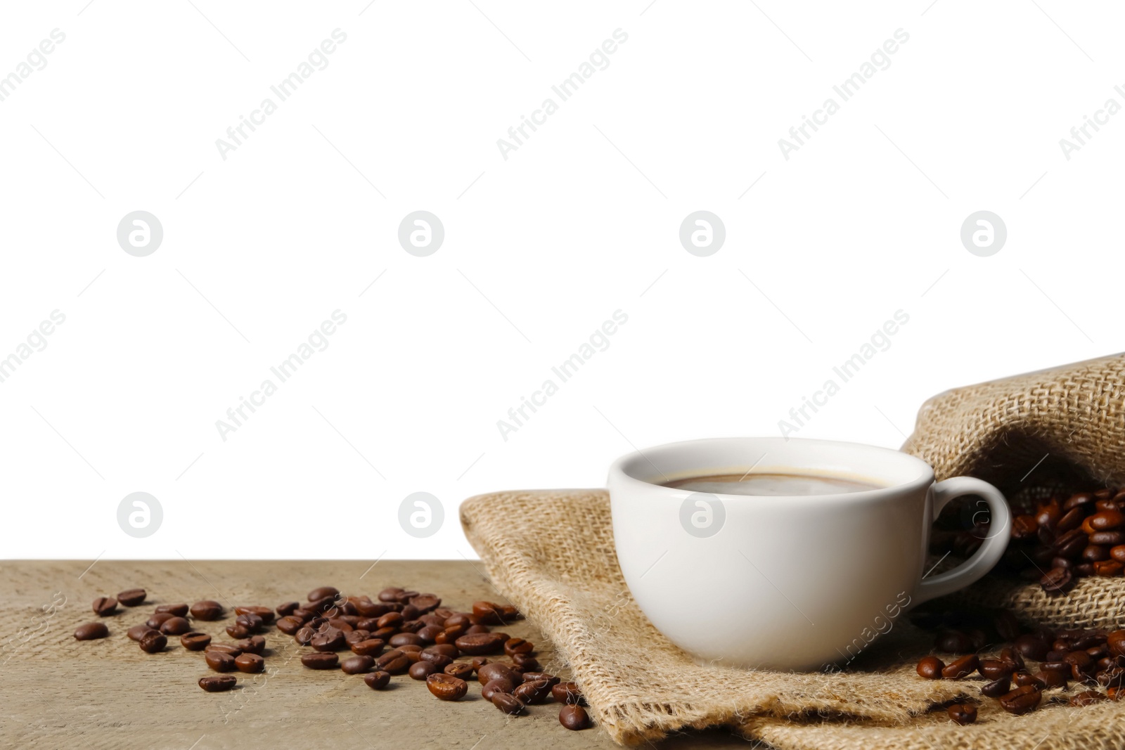 Photo of Cup of aromatic coffee and beans on wooden table against white background