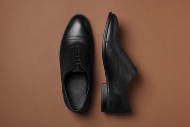 Photo of Pair of leather men shoes on brown background, top view