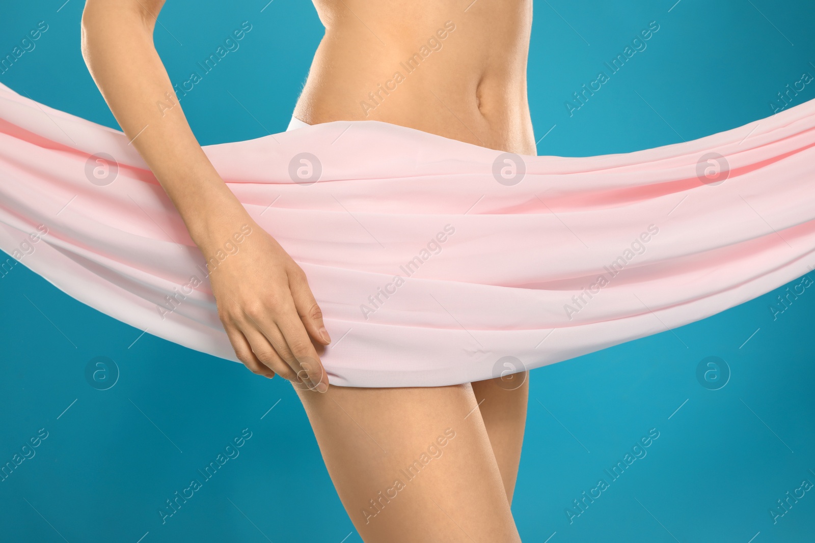 Photo of Slim young woman covered with silk fabric on color background, closeup. Fit body