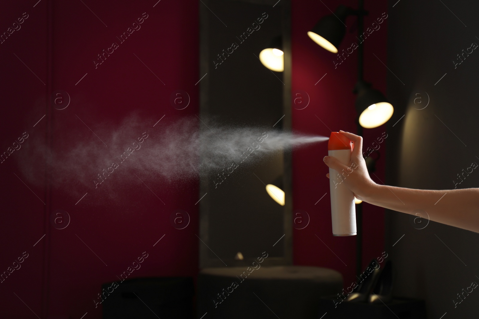 Photo of Woman spraying air freshener at home