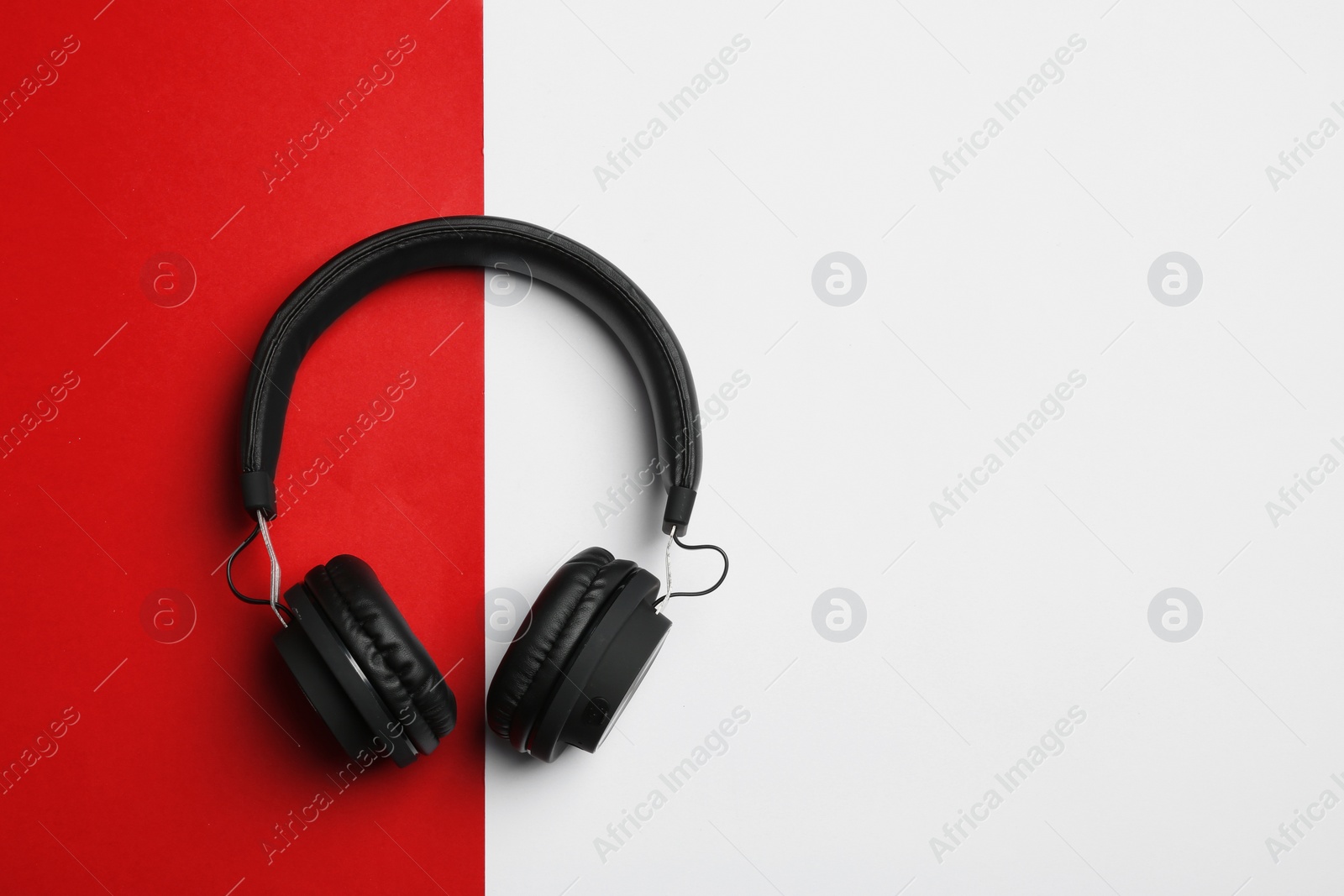 Photo of Stylish headphones on color background, top view. Space for text