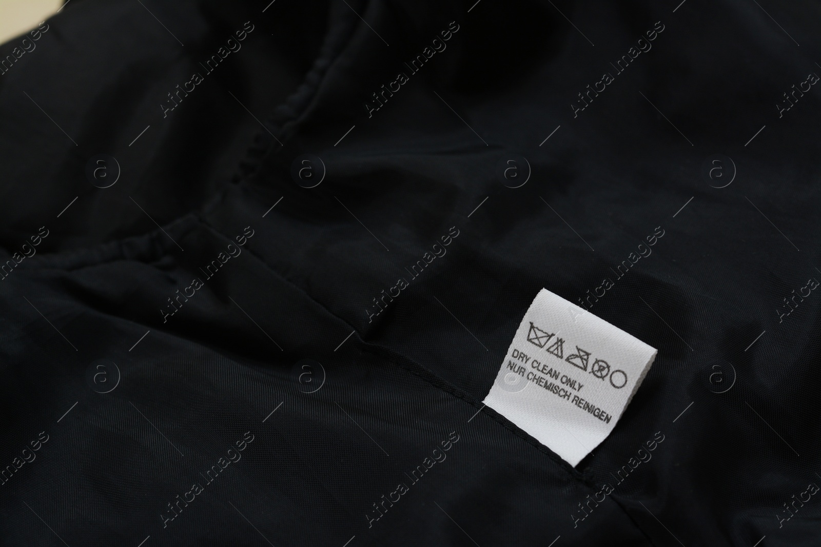 Photo of Clothing label on black garment, space for text