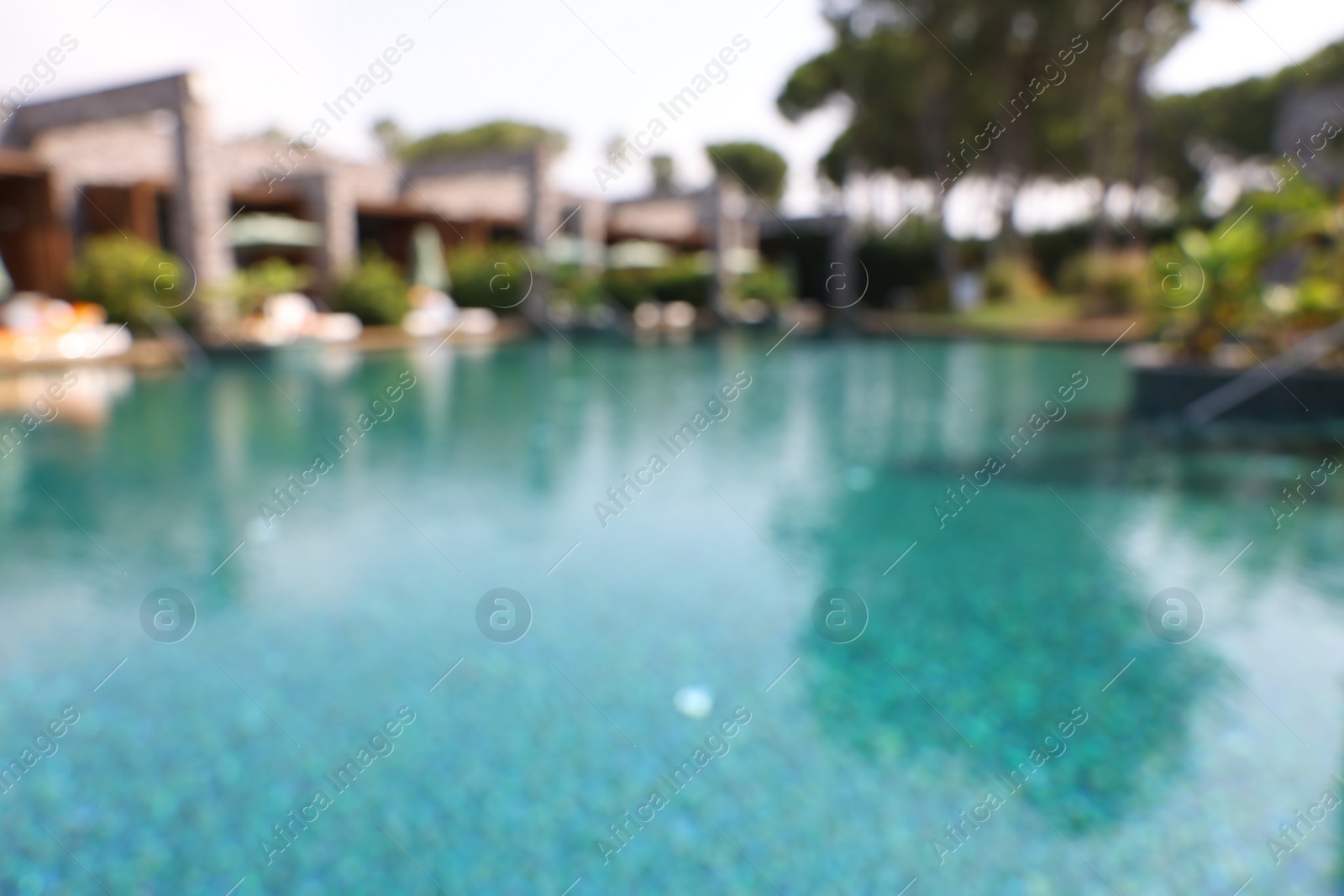 Photo of Luxury resort with outdoor swimming pool and sun loungers on sunny day, blurred view