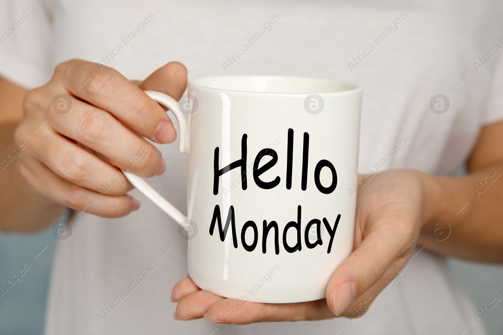 Image of Start your week with good mood. Woman holding ceramic cup with text Hellow Monday, closeup 