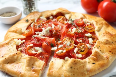 Tasty galette with tomato, thyme and cheese (Caprese galette) on table, closeup