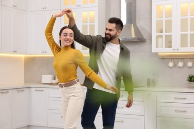 Happy lovely couple dancing together in kitchen