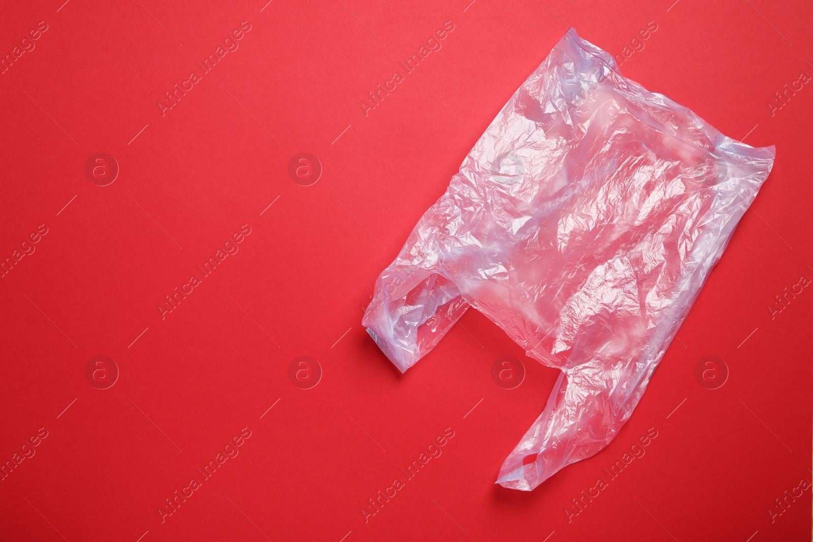Photo of One plastic bag on red background, top view. Space for text