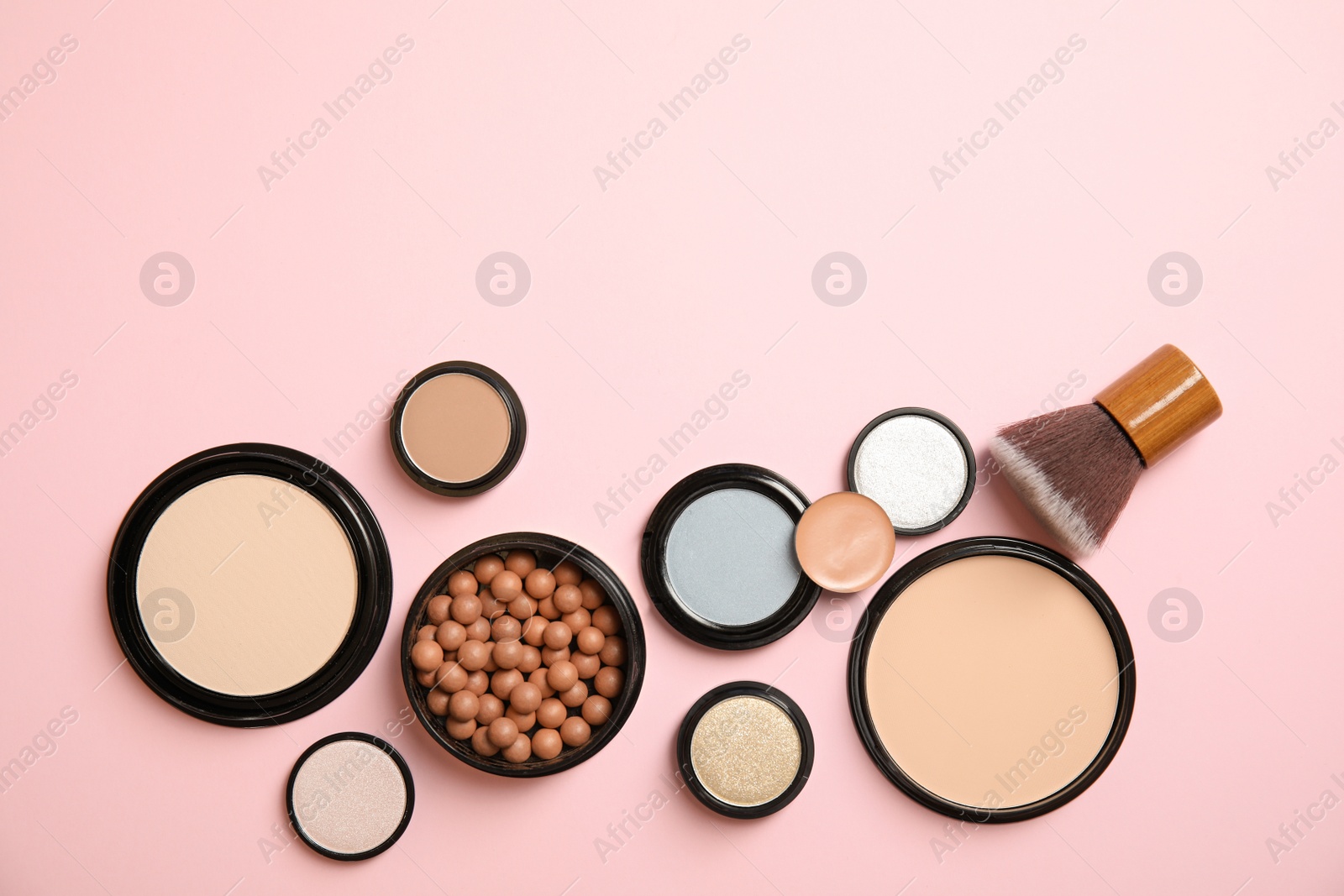 Photo of Flat lay composition with various makeup face powders on color background. Space for text