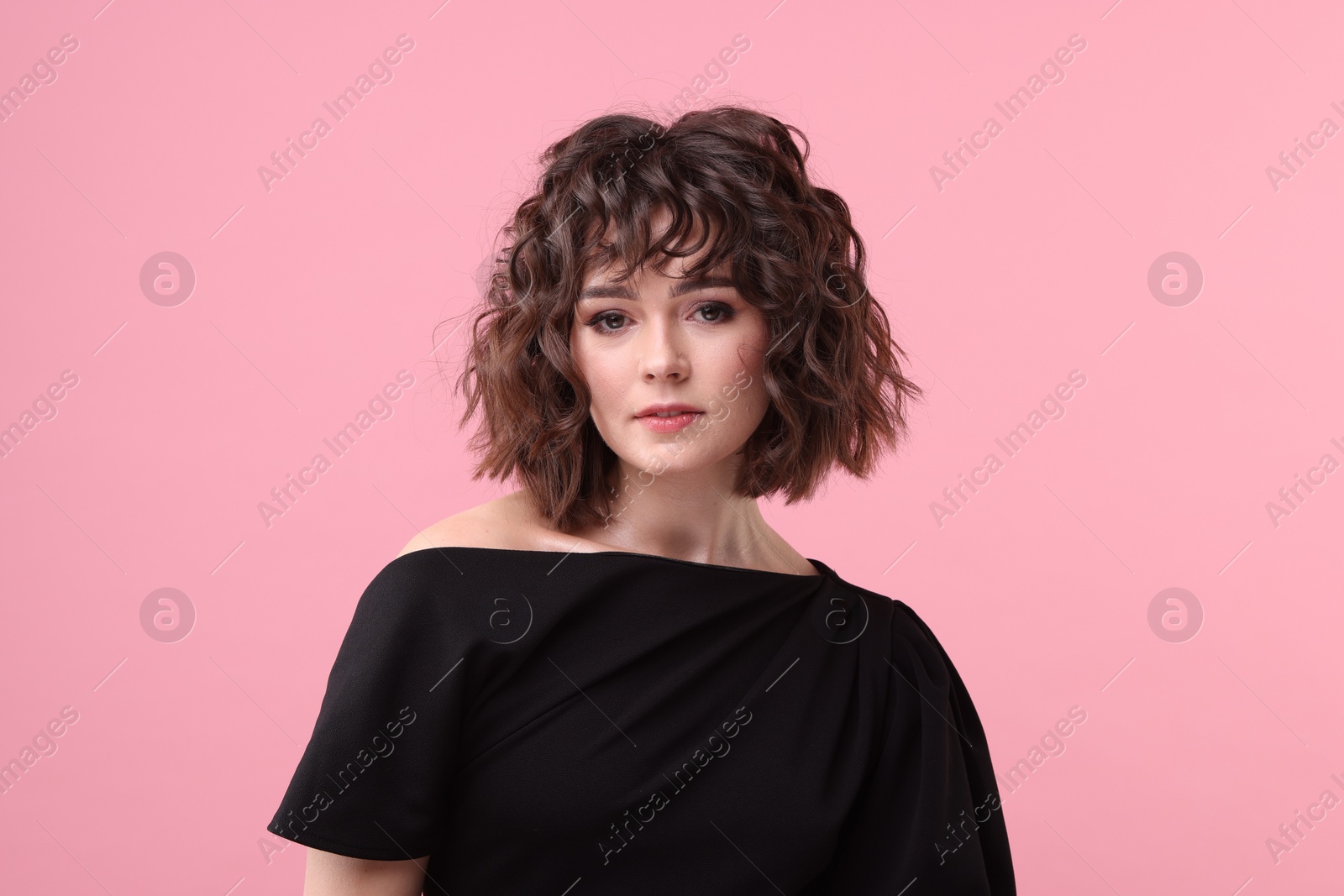 Photo of Portrait of beautiful young woman with wavy hairstyle on pink background