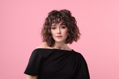 Photo of Portrait of beautiful young woman with wavy hairstyle on pink background
