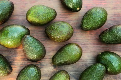 Photo of Many tasty ripe avocados on wooden table, top view