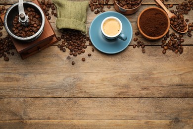 Flat lay composition with coffee grounds and roasted beans on wooden table, space for text