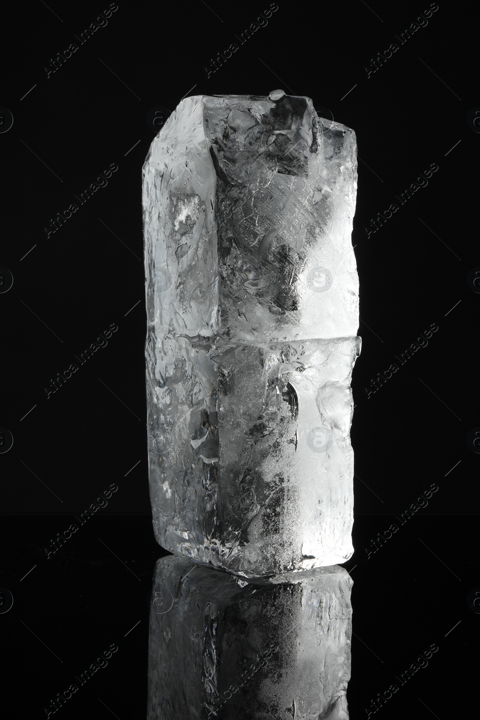 Photo of Blocks of clear ice on black mirror surface