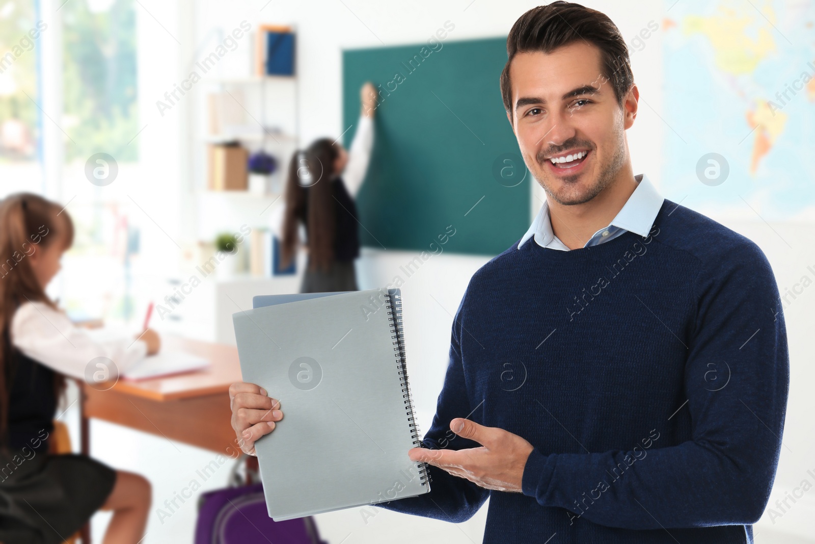 Image of Young school teacher in classroom with students