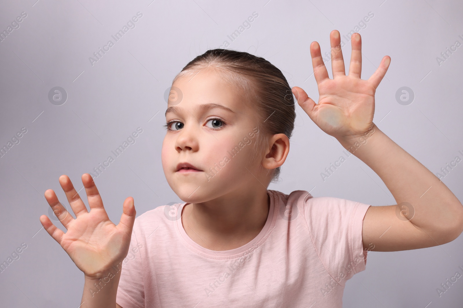 Photo of Cute little girl stuck to transparent screen