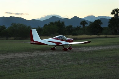 Photo of Ultralight airplane on green grass near beautiful mountains