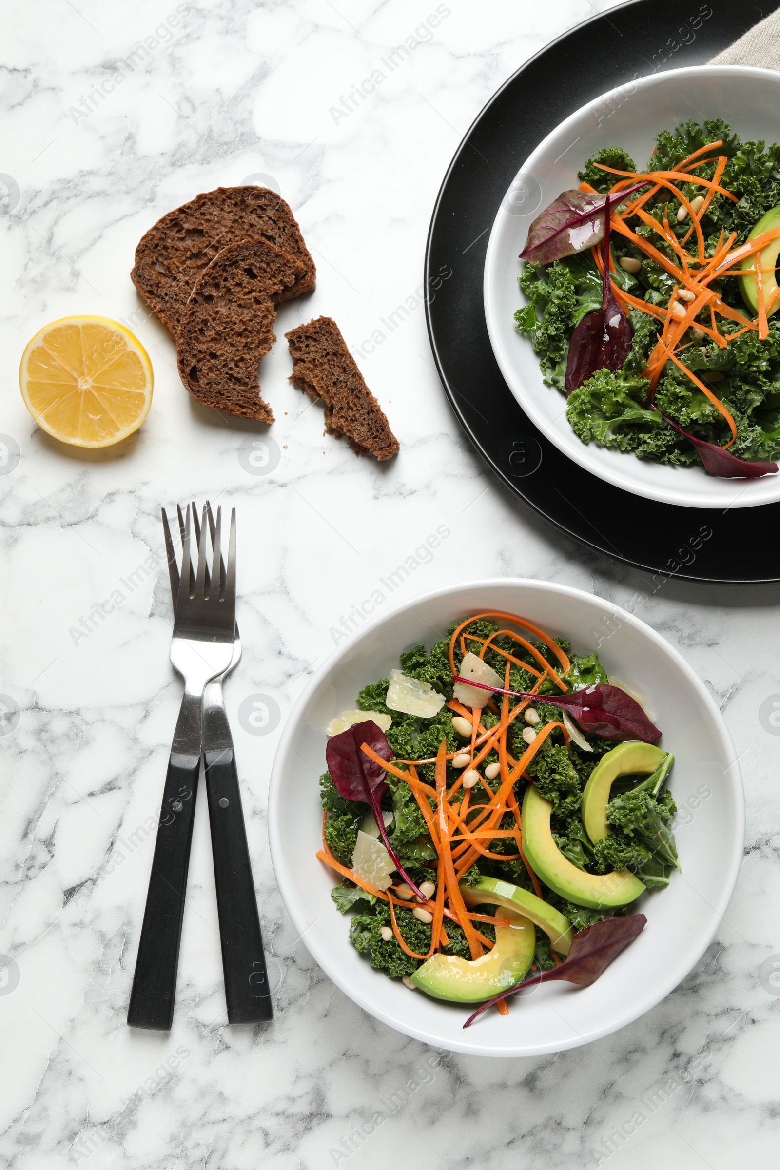 Photo of Tasty fresh kale salad on marble table, flat lay