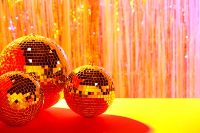 Photo of Shiny disco balls on blurred background, color toned. Space for text