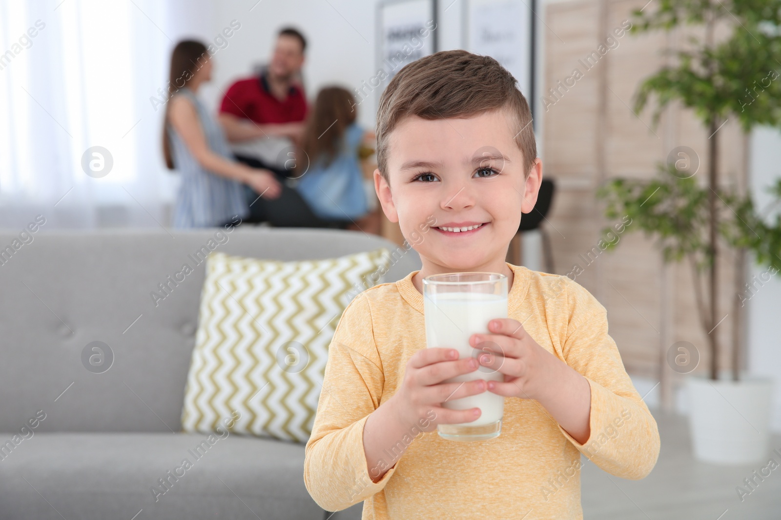 Photo of Cute little boy with glass of milk at home