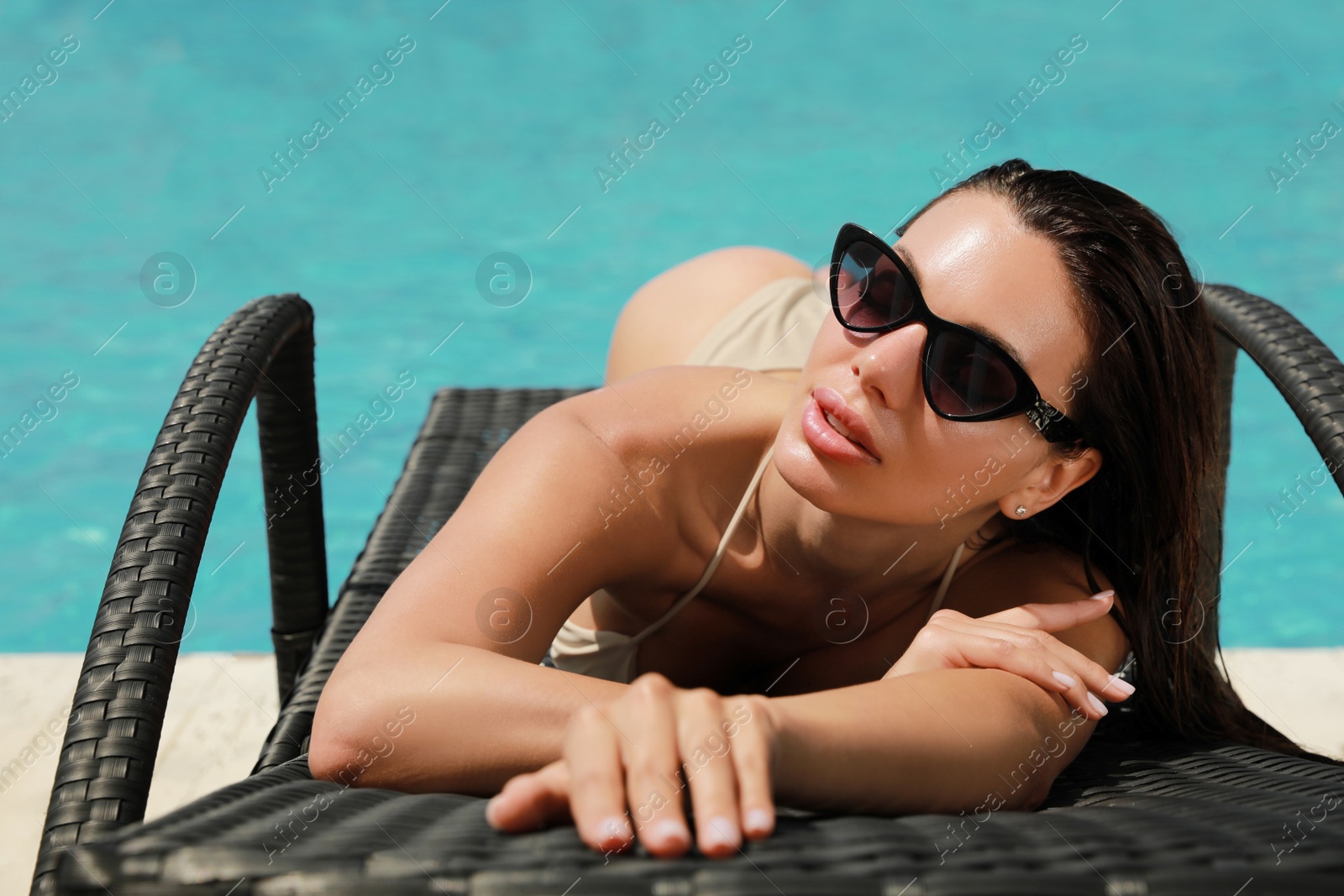 Photo of Beautiful woman in bikini on sunbed near swimming pool