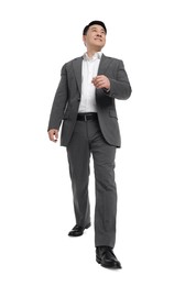 Photo of Businessman in suit walking on white background, low angle view