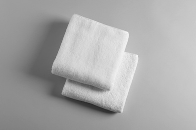 Photo of Soft folded towels on light background, top view