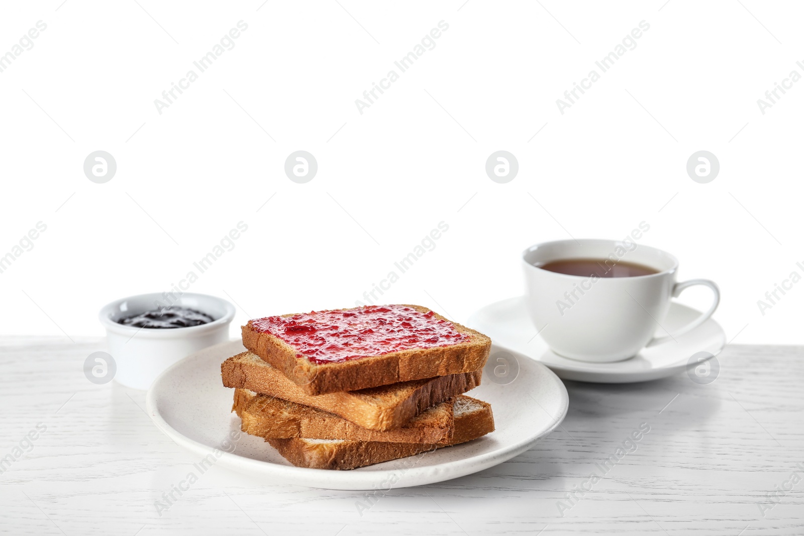 Photo of Toasts with jam and cup of tea on white wooden table